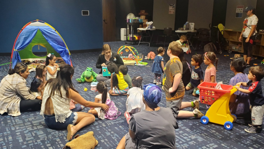 Group of young children and parents listening to dentist