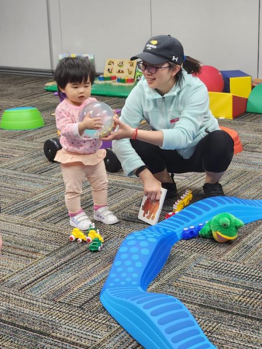 Child and parent playing with a ball at our Playful Parenting Program.