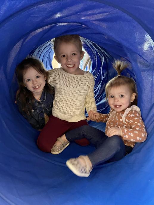 Three children inside play tunnel