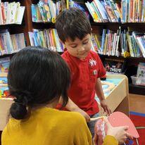 Little friend brushing a giant set of teeth during Stay and Play.