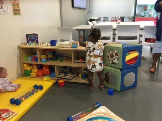 Infant play area with interested toddlers.