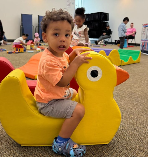 toddler enjoying a duck toy