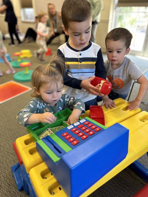 children exploring toy cash register