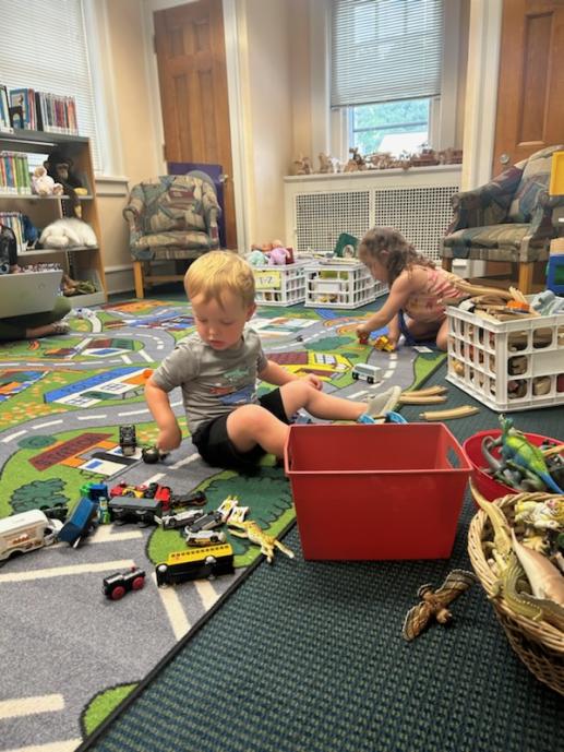 Children can play with toy vehicles and construction toys in the play room.