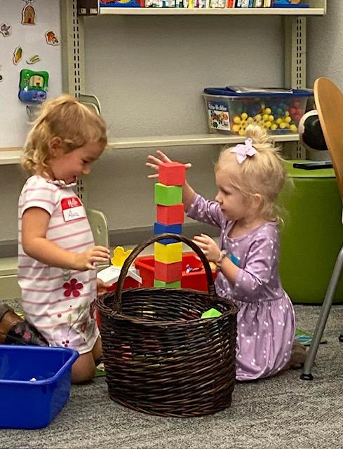 Two girls enjoying the building blocks.