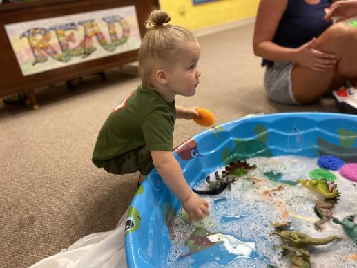 Washing dinosaurs during a Let's Play! Together program