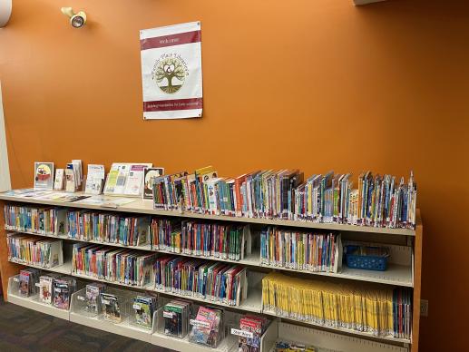 Children's bookshelf with Family Place flag hanging above. 