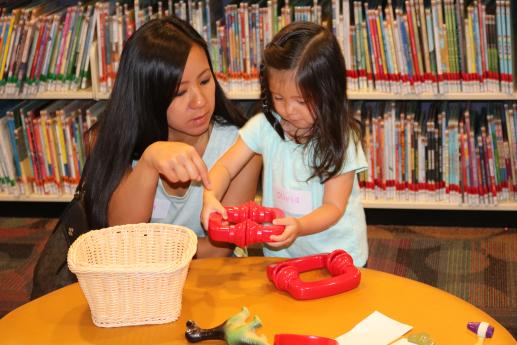 Caregiver and child playing with early learning manipulatives at the Biane Library