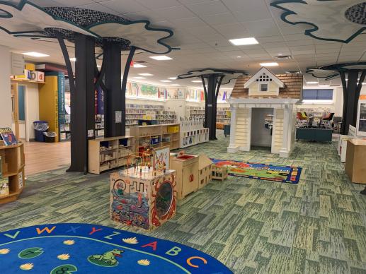 early childhood play area in chdlren's library with storytbook house