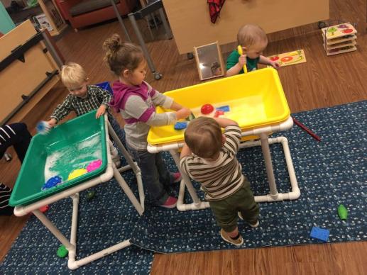 Children playing in water sensory bins.