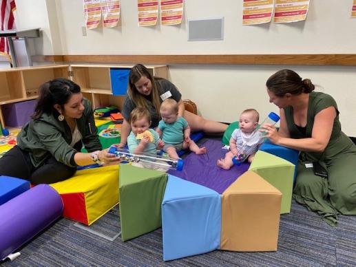 Parents and babies exploring sensory tubes and soft toys