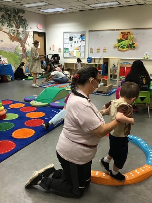 Child on balance toy, gross motor, and dramatic play at Family Place Workshop with Speech Professional